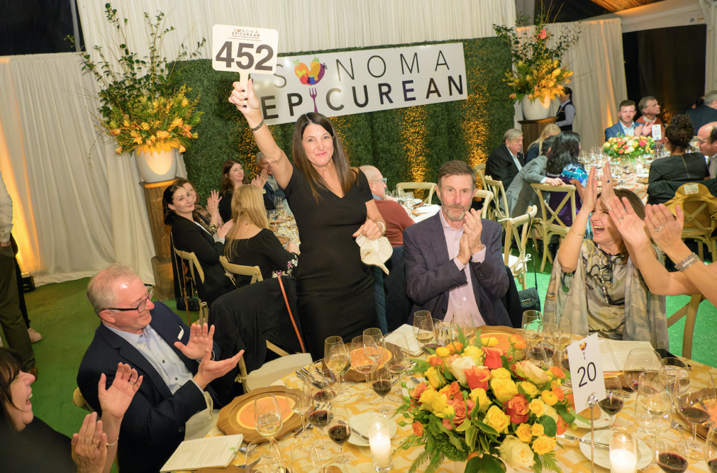 Patricia Decker celebrates a winning bid at auction. Photo Courtesy: V Foundation Sonoma Epicurean.