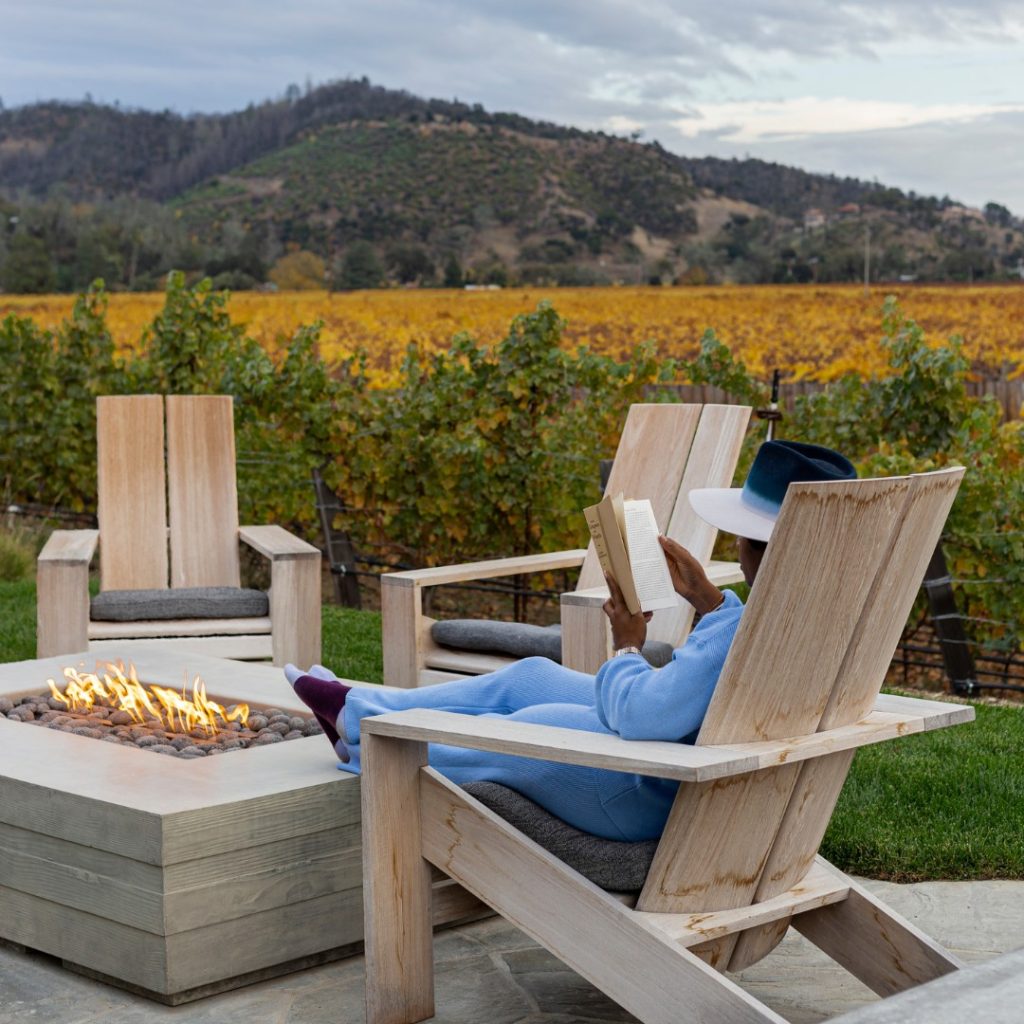 Guest enjoying a book by the fire at Four Seasons Napa Valley Private Residence.
