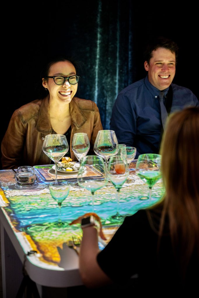 Guests smiling and enjoying oysters at The Radiant Table