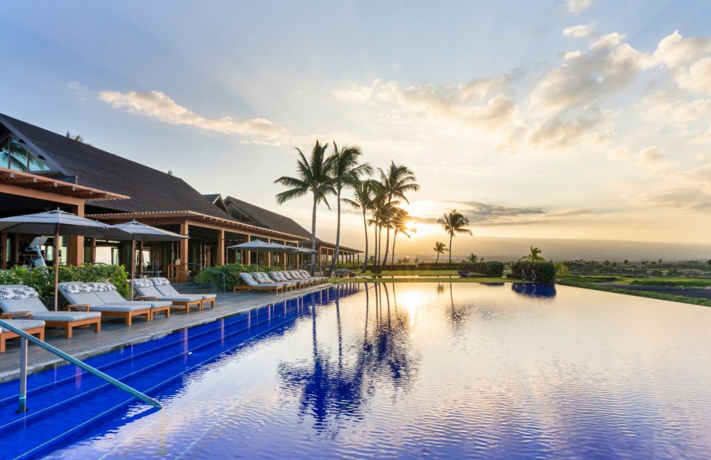 Sunset view over the serene infinity pool at Kohanaiki luxury retreat.