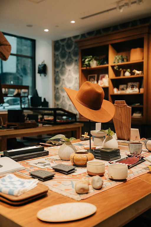 Boutique gift shop display with brown hat and handmade items.