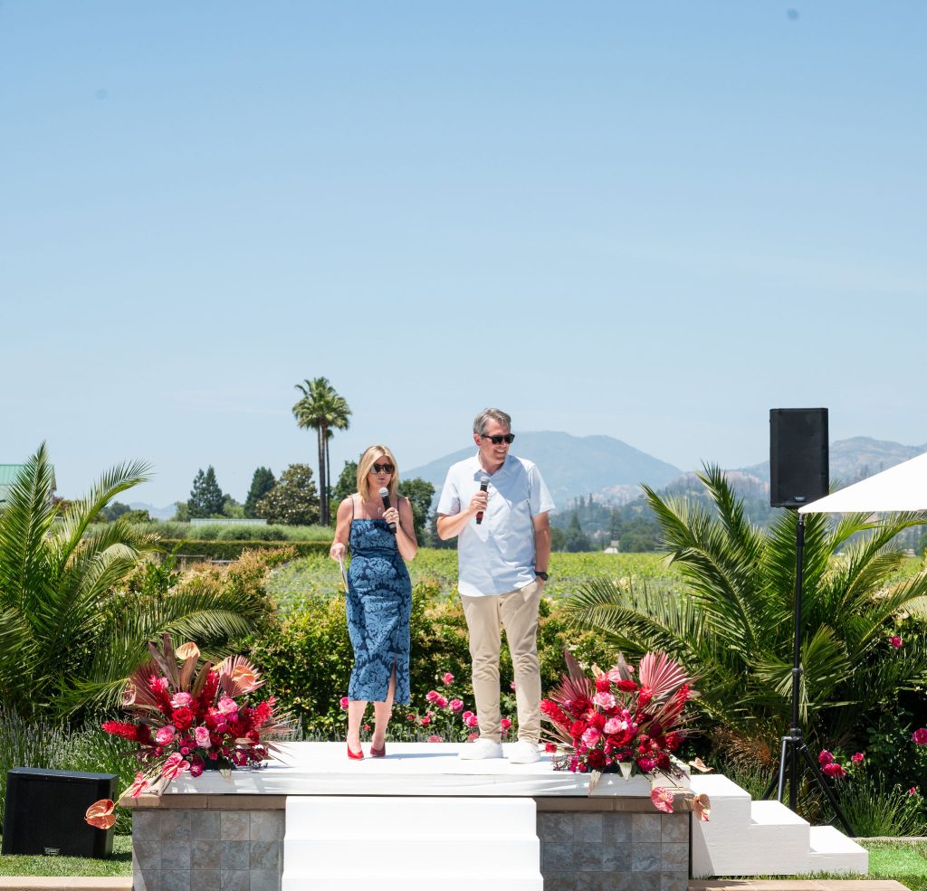 Event speakers onstage at the Runway for Red fundraiser, set against Napa Valley’s scenic vineyard and mountain backdrop.