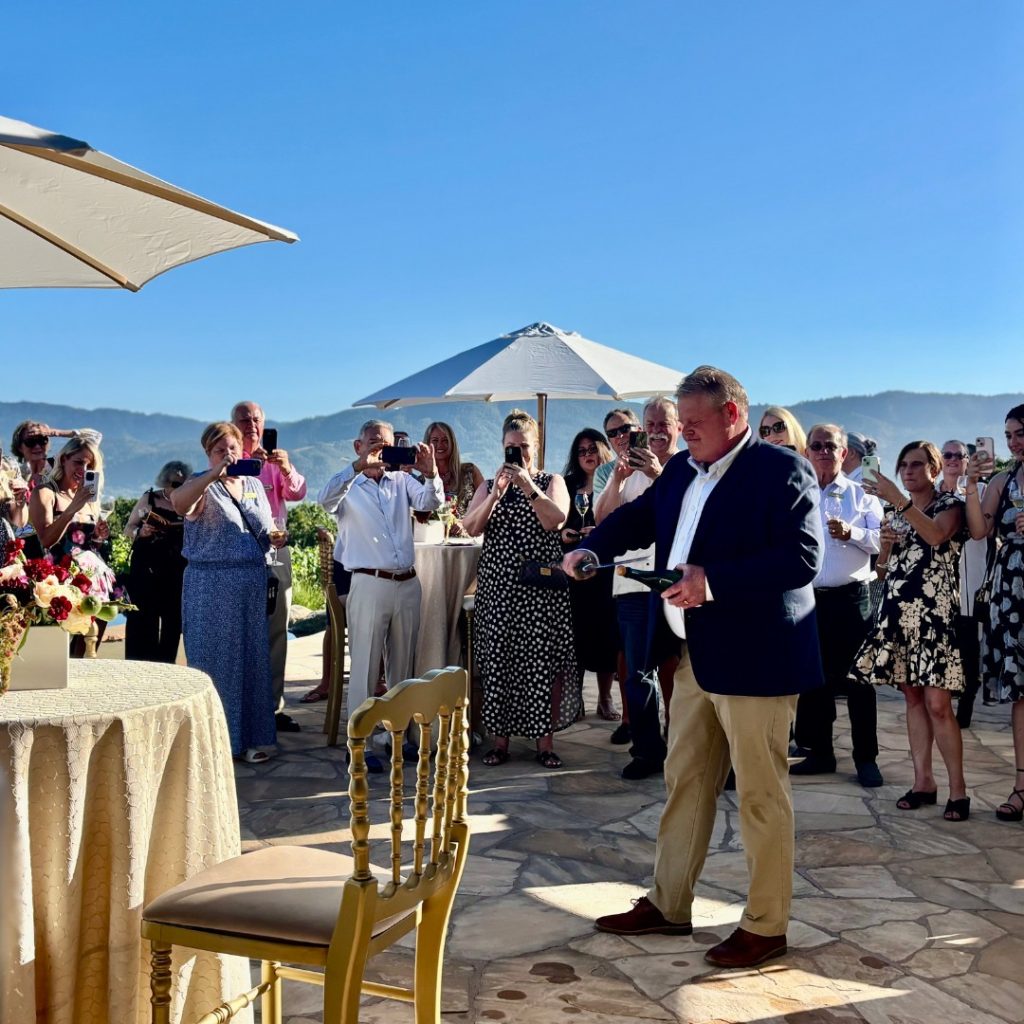Winemaker Mike Reynolds sabering Champagne during release party.