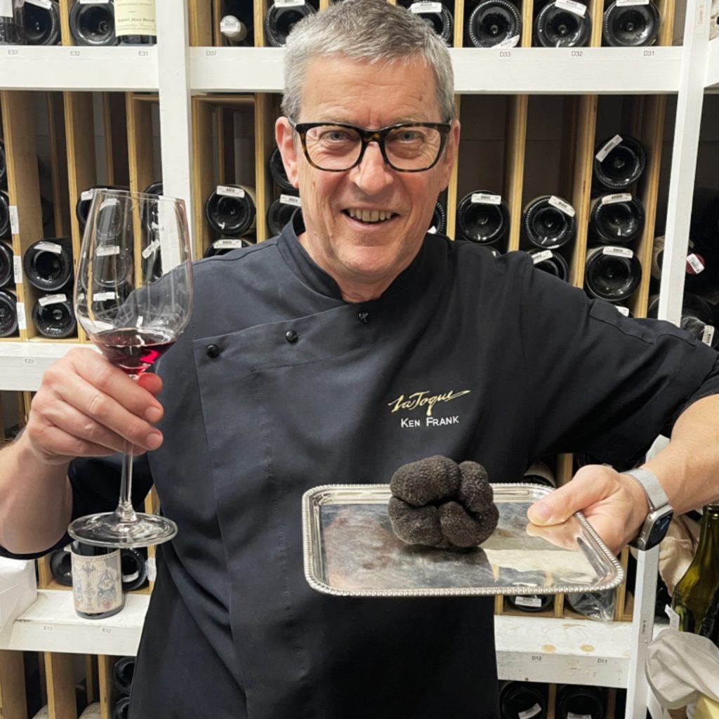 Chef Ken Frank holding black truffles and wine at La Toque restaurant.