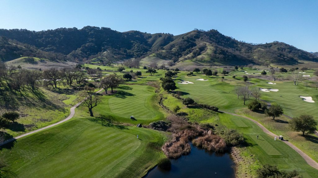 Panoramic aerial view of CordeValle’s championship golf course nestled among rolling green California hills.