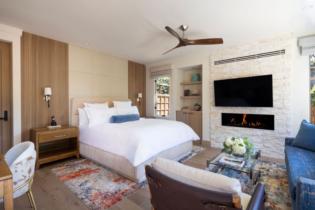 Luxury bedroom suite at CordeValle with plush king bed, fireplace, and cozy seating area for a relaxing retreat.