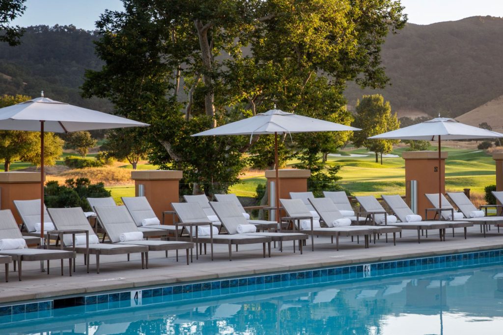 Sunlit resort pool deck at CordeValle, perfect for relaxation with a backdrop of California’s rolling hills.