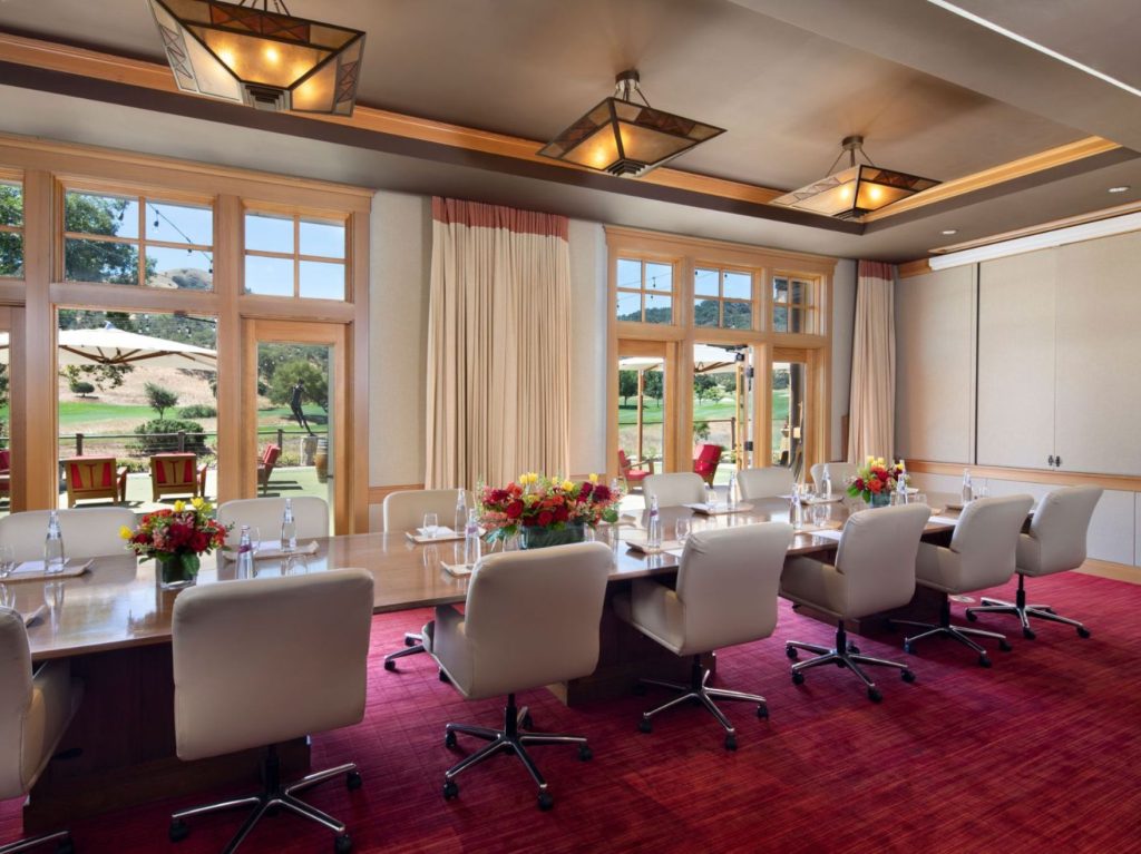 Elegant conference room at CordeValle with floor-to-ceiling windows and a view of the golf course patio.