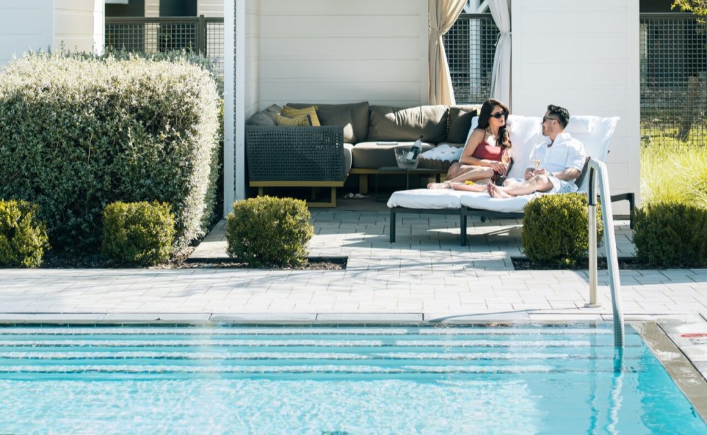 Guests in cabana by pool at at Four Seasons Resort and Residences Napa Valley.